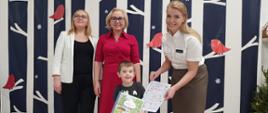Dyrekcja Przedszkola wraz z przedstawicielką Nadleśnictwa Hajnówka wręczają nagrody dzieciom, pozując do wspólnego zdjęcia