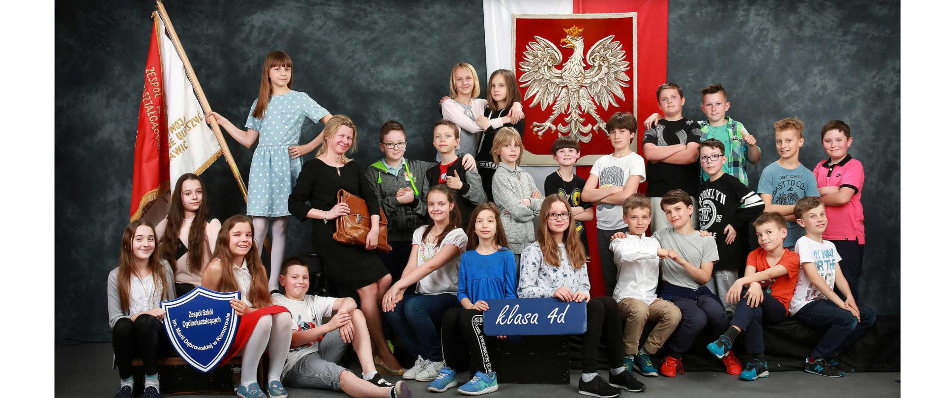 Grupa dzieci. Za nimi godło Polski