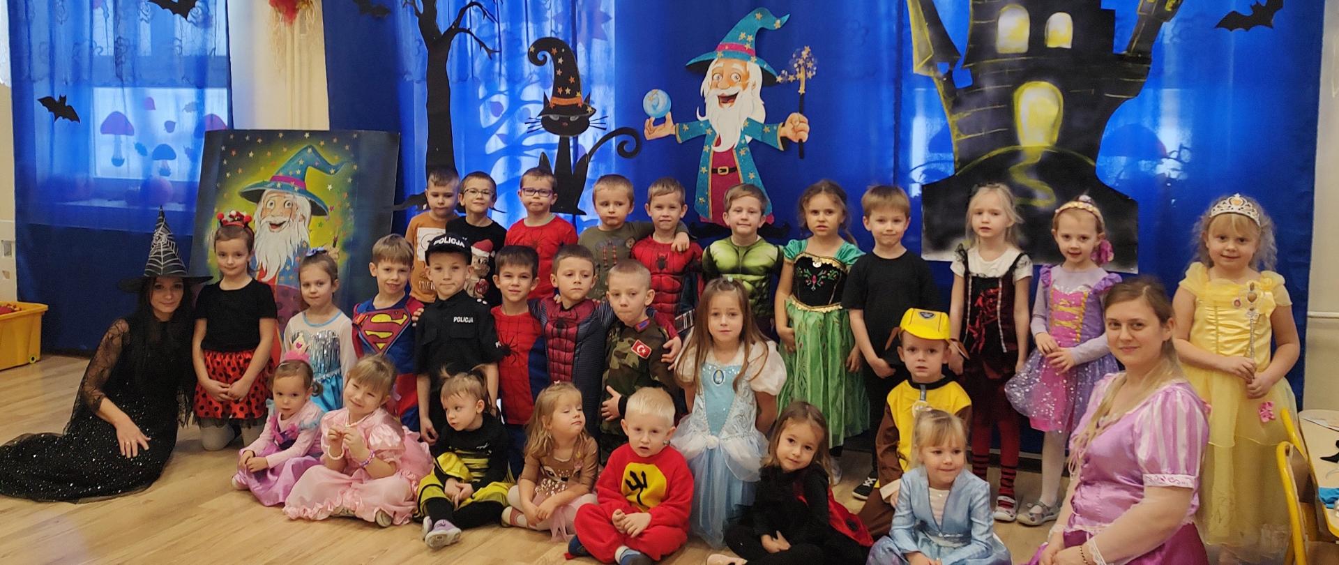 Zdjęcie grupowe „Maluszków” oraz „Straszaków” na tle dekoracji andrzejkowej.