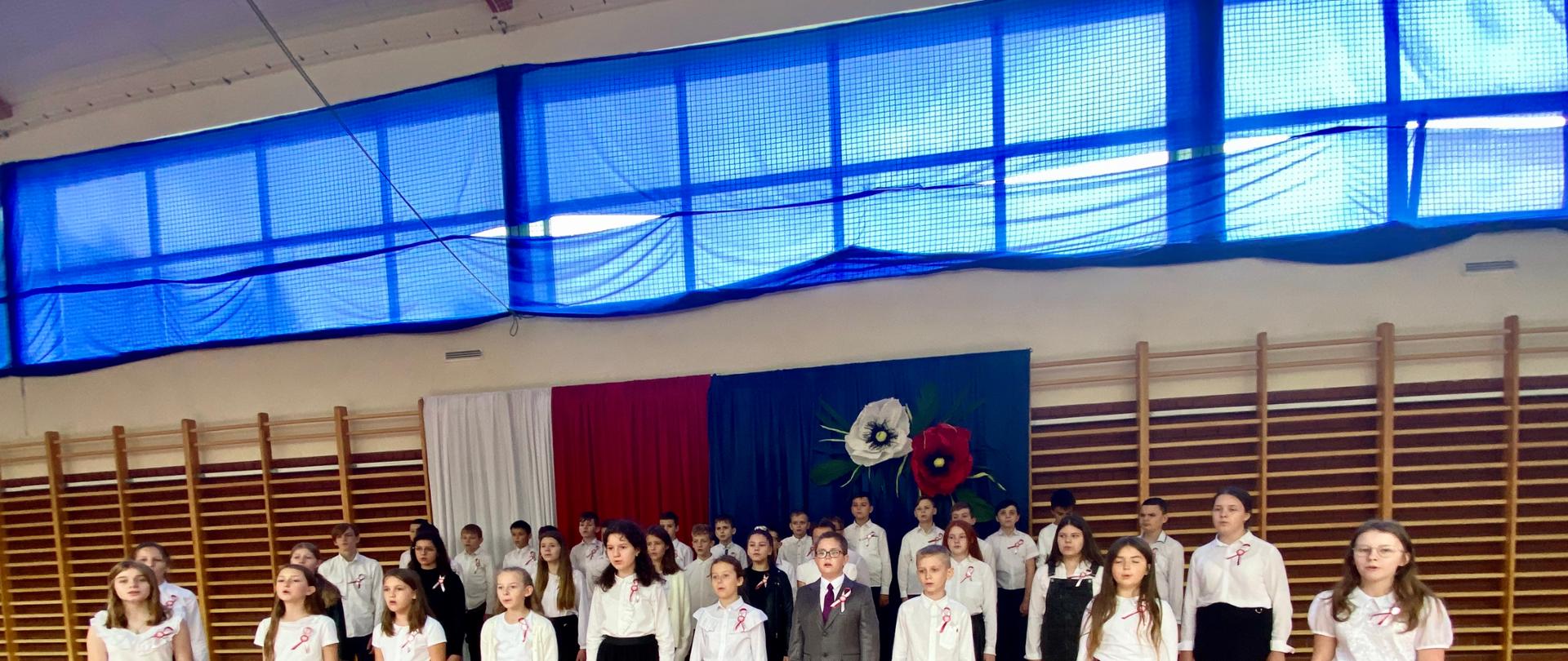 Uczniowie podczas śpiewania hymnu i pieśni patriotycznych.
