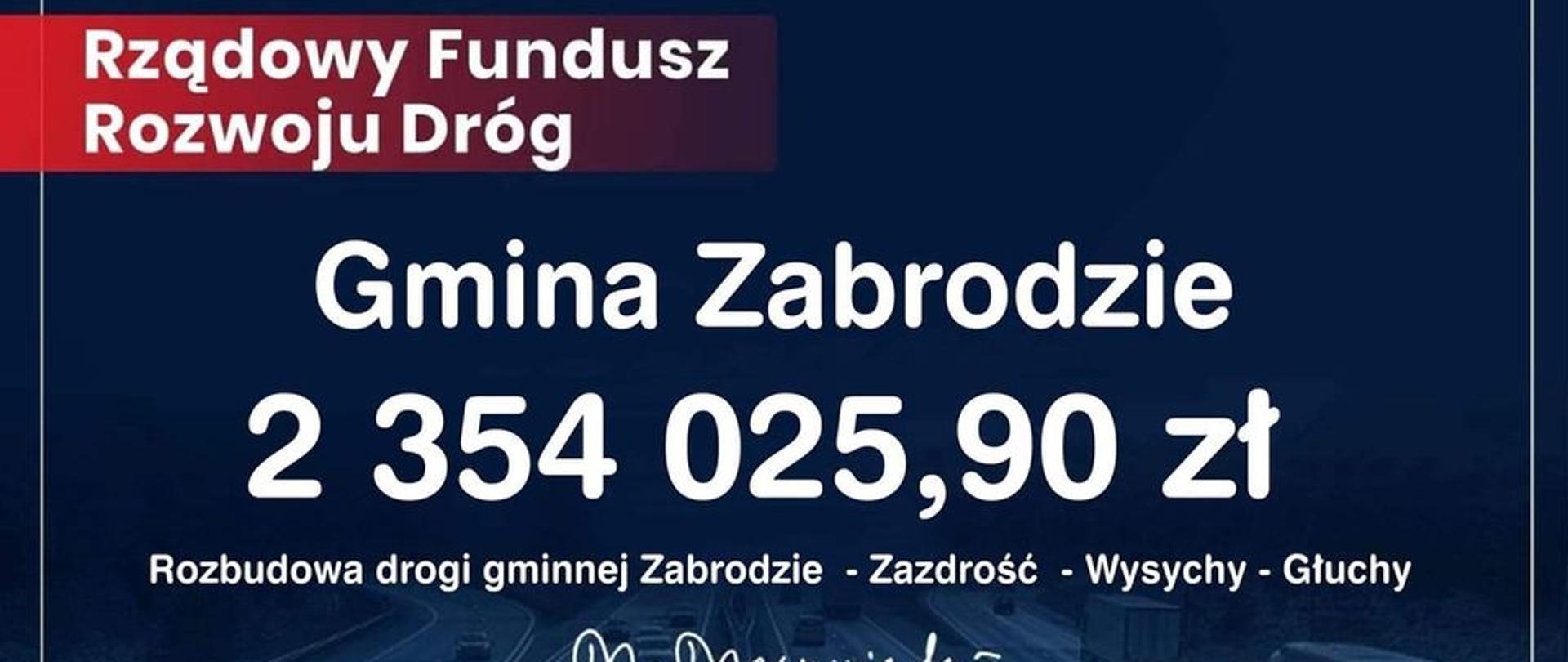 Granatowa tablica z białym napisem na czerwonej wstędze po lewej stronie: Rządowy Fundusz Rozwoju Dróg. Na środku duży biały napis: Gmina Zabrodzie 2354025,90zł. Rozbudowa drogi gminnej Zabrodzie-Zazdrość-Wysychy-Głuchy