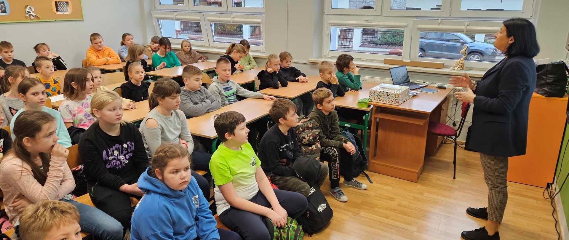 kobieta przemawia do dzieci w klasie