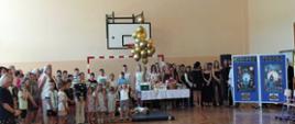 Rodzice i uczniowie z pozostałych klas oglądają pożegnanie absolwentów, dekoracja przedstawia wehikuł czasu