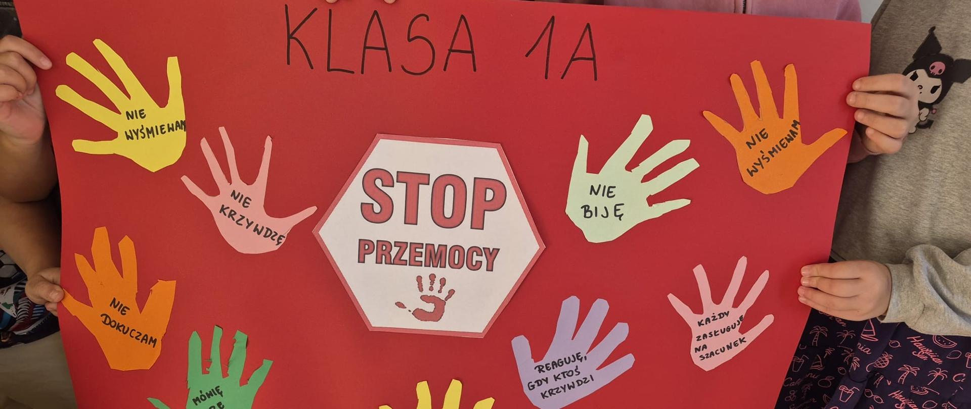 Uczniowie prezentują plakat z hasłem „STOP przemocy”. Kolorowe dłonie z napisami wyrażają sprzeciw wobec przemocy i promują życzliwość, szacunek oraz wzajemne wsparcie.