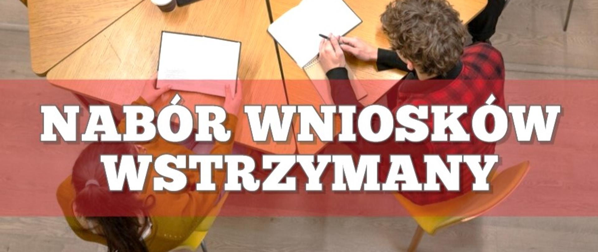 nabór wniosków wstrzymany program Czyste Powietrze, dwójka ludzi siedzi przy stole na którym leżą dokumenty, na pierwszym planie wyróżnia się napis: NABÓR WNIOSKÓW WSTRZYMANY na prześwitującym czerwonym tle