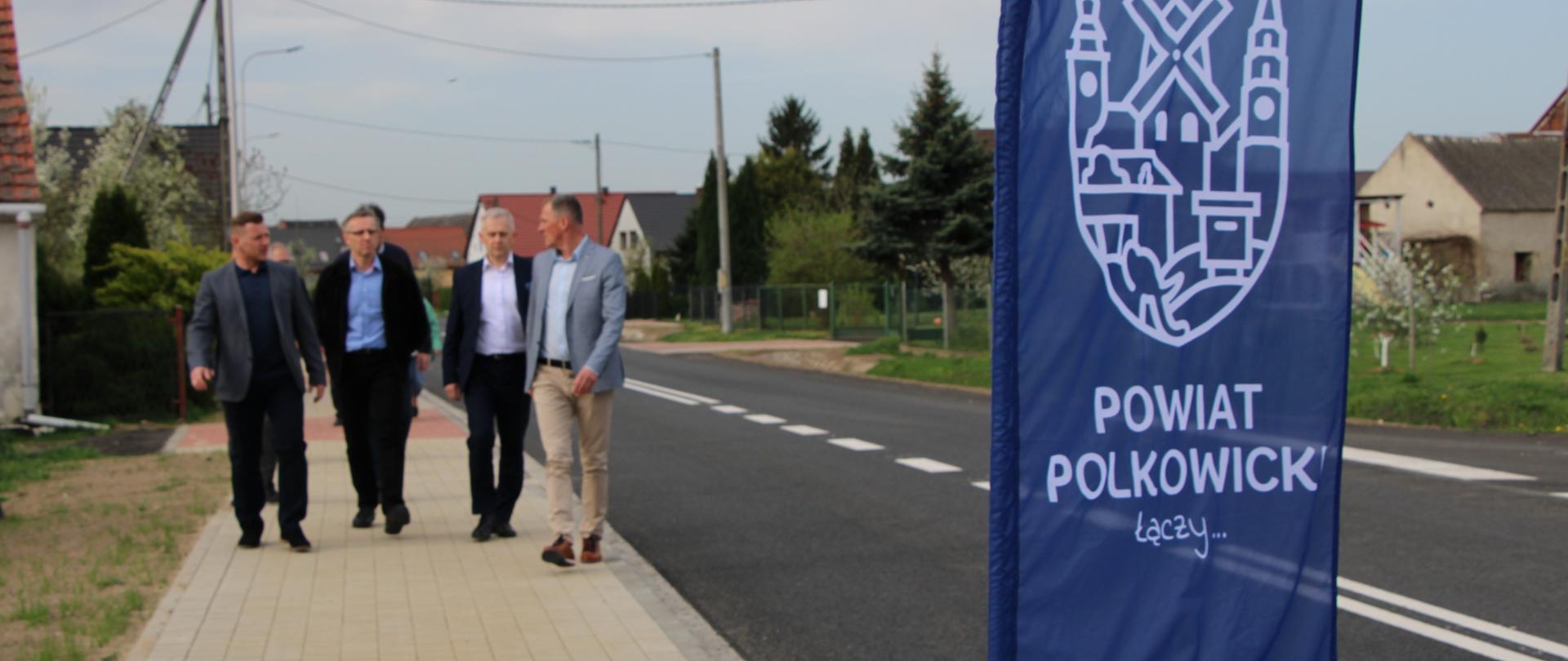 Ludzie idą chodnikiem.