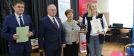 Przedstawicielka Politechniki Białostockiej odbiera nagrodę Starosty Hajnowskiego - obok niej do zdjęcia pozują Starosta Hajnowski, Zastępca Burmistrza Miasta i Naczelnik Wydziału Spraw Społecznych