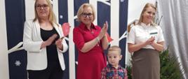 Dyrekcja Przedszkola wraz z przedstawicielką Nadleśnictwa Hajnówka wręczają nagrody dzieciom, pozując do wspólnego zdjęcia