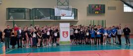 Uczestnicy turnieju stojący wspólnie na hali sportowej