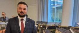 Marek Cyl na tle zdjęcia szkoły w Świerklańcu