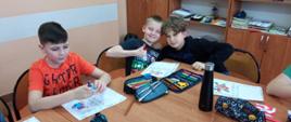 na zdjęciu uczniowie kolorują kartki świąteczne