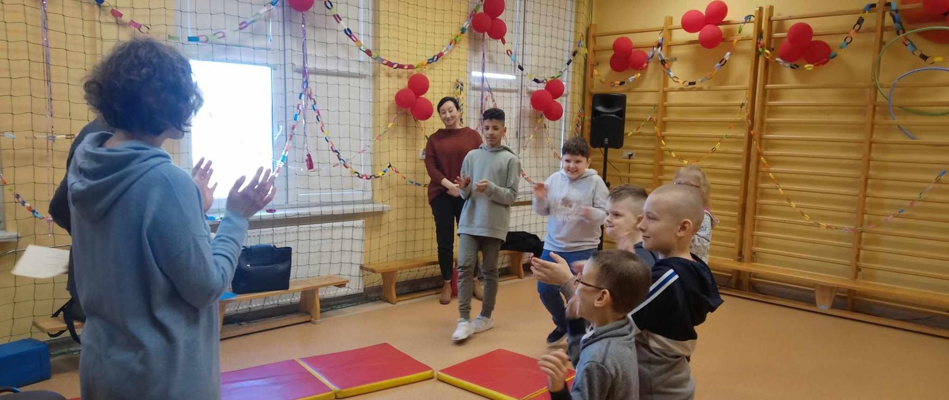Podczas ćwiczeń - dzieci otaczają pedagog prowadzącą zajęcia