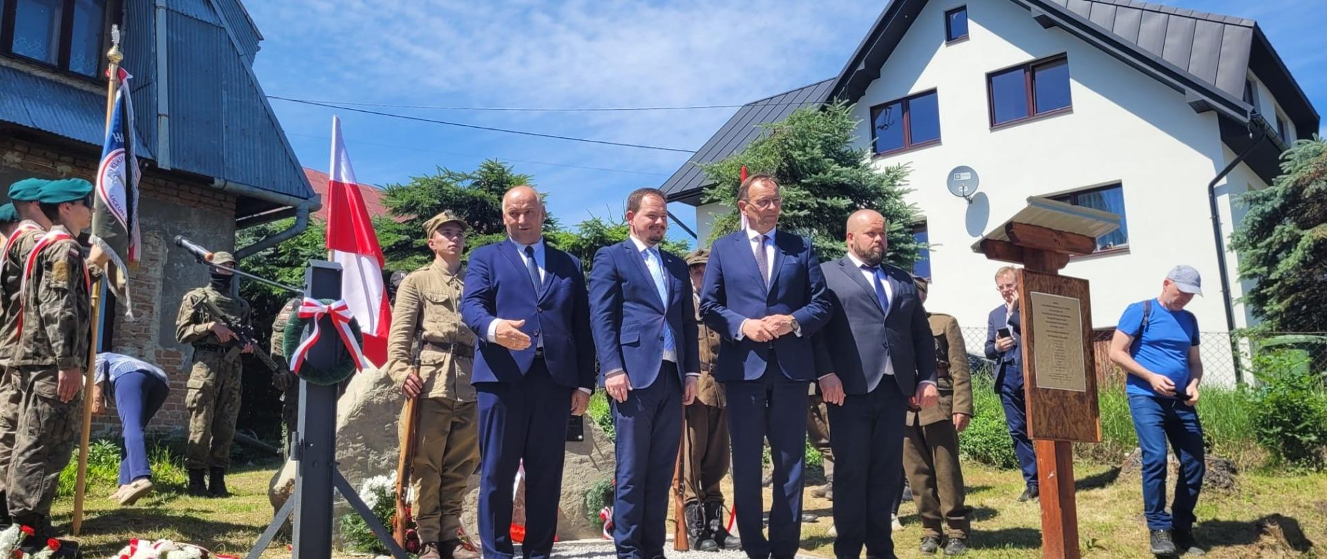 Na tle biało- czerwonej flagi i wiązanki organizatorzy Rajdu.