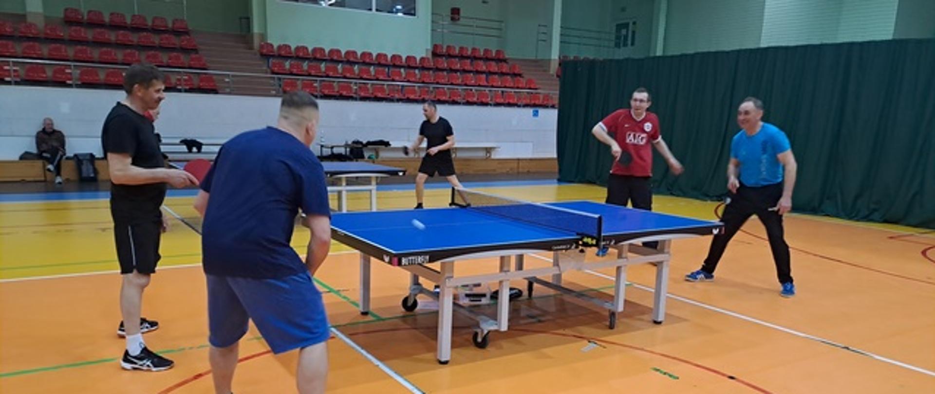 Runda meczowa - czterech mężczyzn w parach gra przy stole