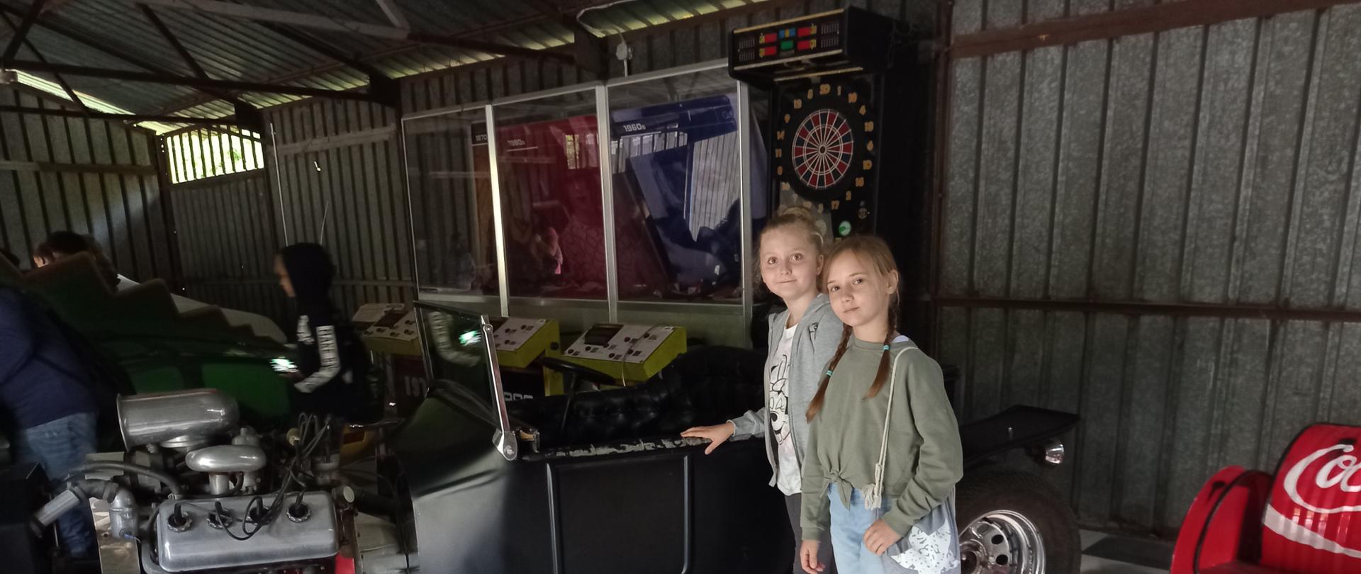 Dwie dziewczynki przy czarnym samochodzie bez dachu