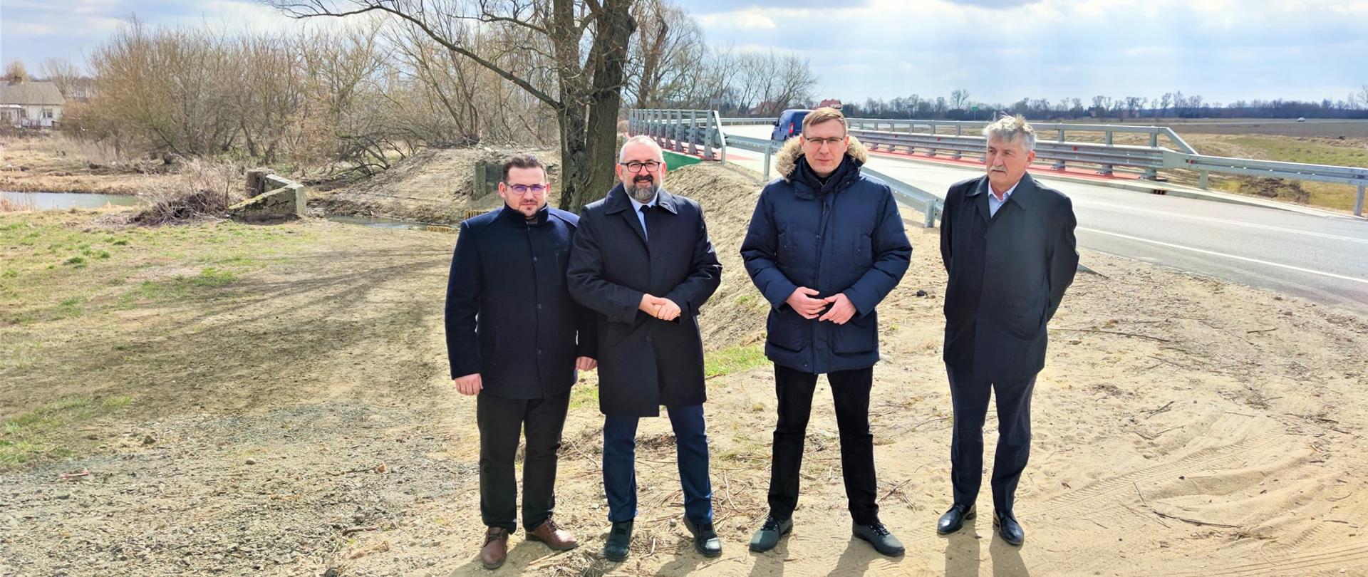 Most w Obrębie został oficjalnie oddany do użytku. Na zdjęciu od lewej strony stoją Etatowy Członek Zarządu Powiatu Przasnyskiego Paweł Mostowy, Starosta Powiatu Przasnyskiego Krzysztof Bieńkowski, Minister Aktywów Państwowych Maciej Małecki oraz Dyrektor Powiatowego Zarządu Dróg w Przasnyszu Kazimierz Pióro. W tle nowy most.