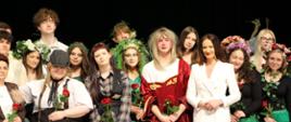 Grupa młodzieży podczas występu teatralnego na scenie wraz ze starostą zambrowskim. 