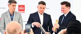 Uczestnicy wydarzenia składają tubę podczas ceremonii wmurowania kamienia węgielnego.