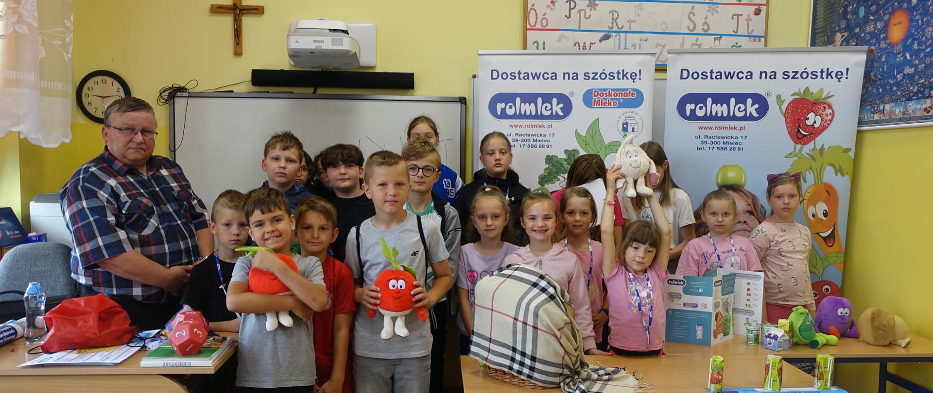 Uczniowie w sali lekcyjnej - wspólne zdjęcie z pracownikiem firmy Rolmlek.