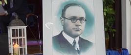 Oprawiony w ramę portret Stanisława Miłkowskiego z podpisem oraz datami urodzin i śmierci (1905–1945), ustawiony obok lampionu ze świecą.