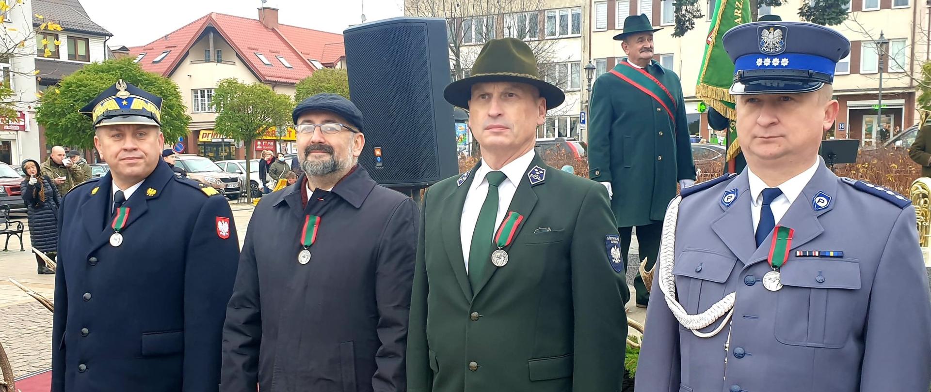 Ciechanowski Hubertus 2021 – Starosta Przasnyski odznaczony medalem za zasługi dla łowiectwa okręgu ciechanowskiego. Zdjęcie przedstawia czterech mężczyzn odznaczonych medalem zasług dla łowiectwa, w tym Starostę Przasnyskiego Krzysztofa Bieńkowskiego, drugi od lewej. Pozostali panowie to przedstawiciele służb mundurowych.