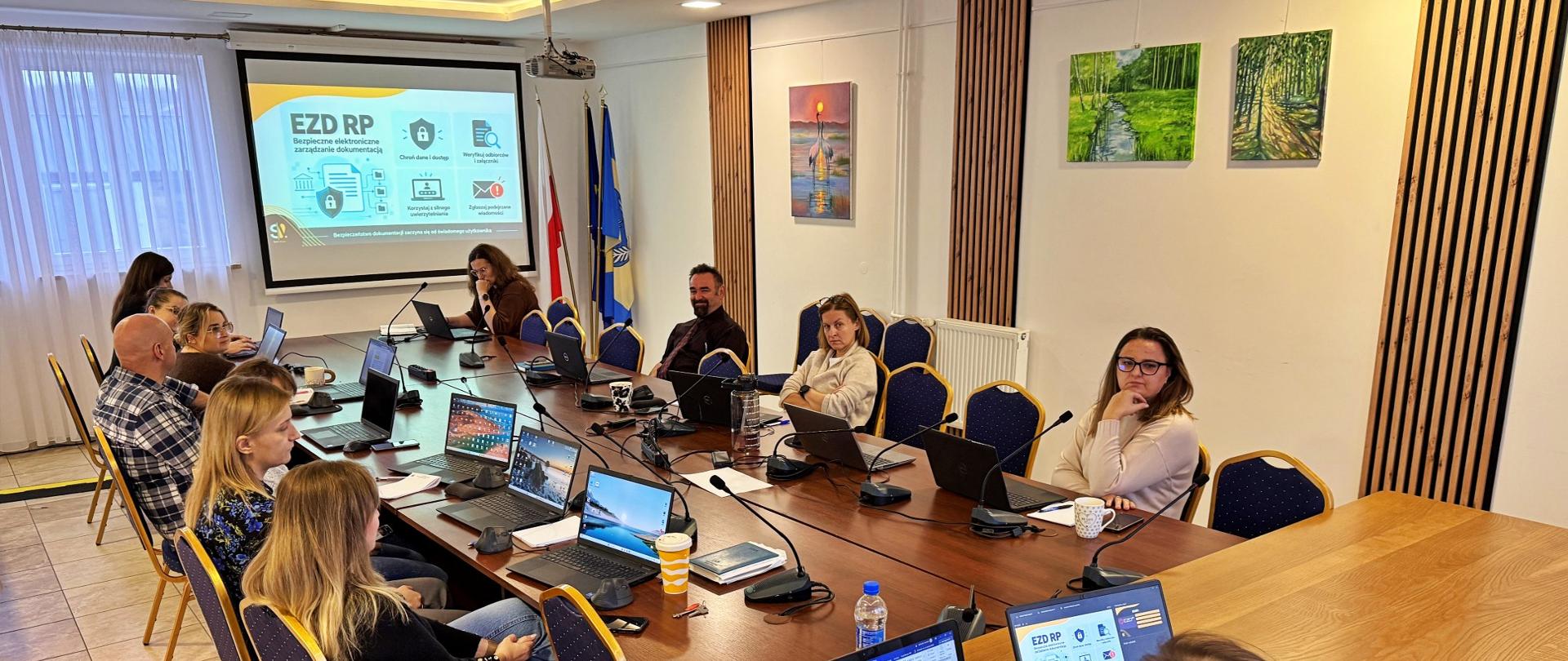 ludzie w sali konferencyjnej siędzą przy stole