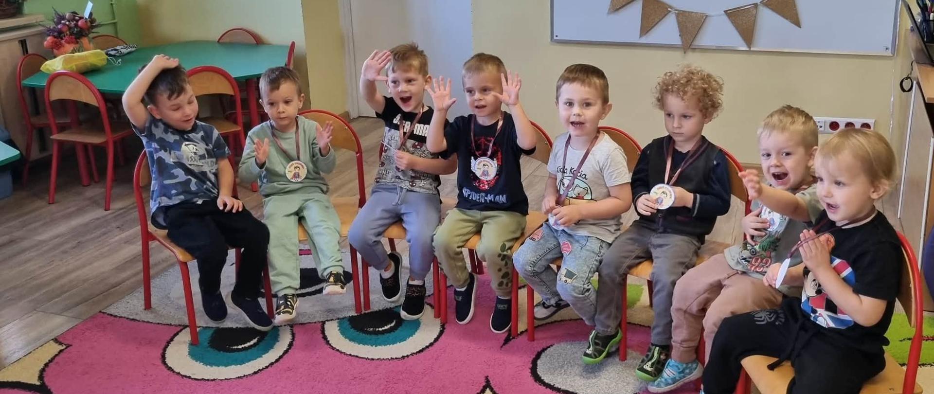 Grupa dzieci pozuje z prezentami z okazji Dnia Chłopaka