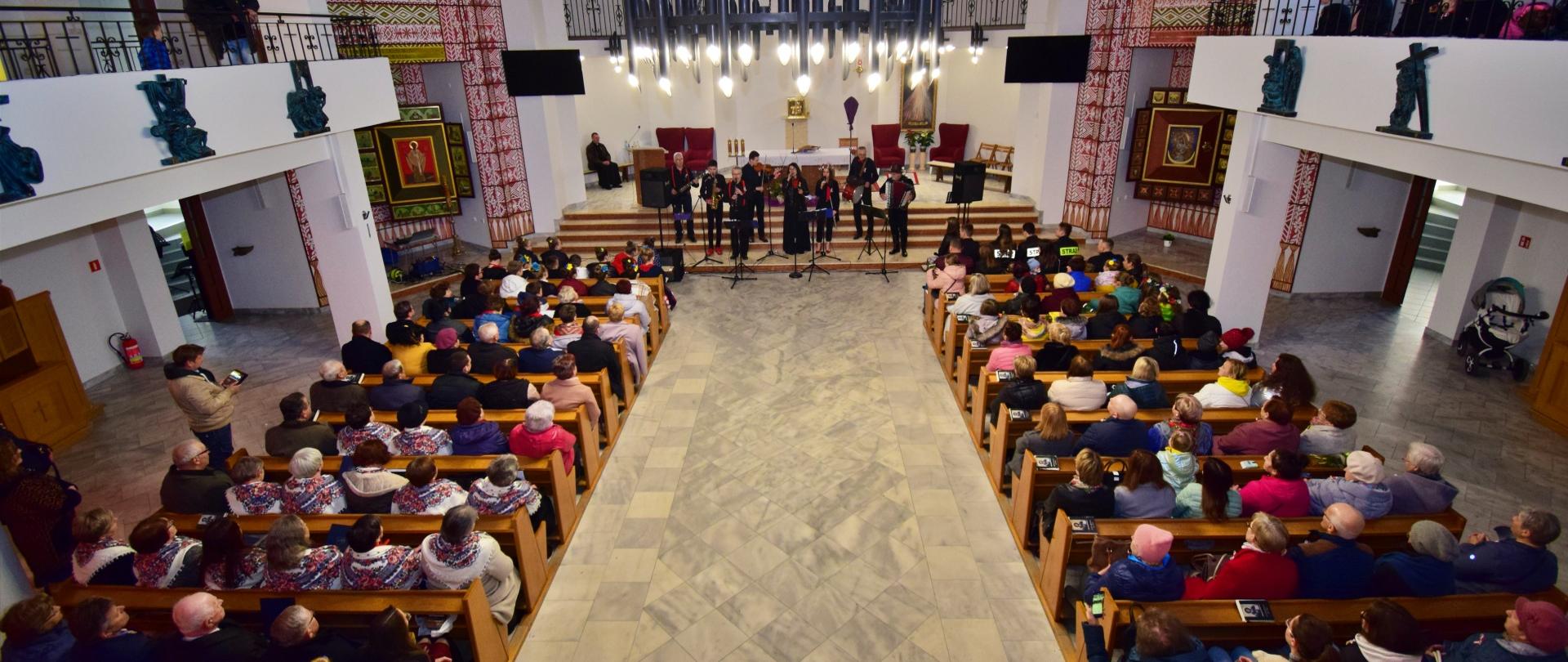 Zdjęcie przedstawia uczestników kiermaszu wielkanocnego, oraz charytatywnego koncertu na rzecz uchodźców z Ukrainy