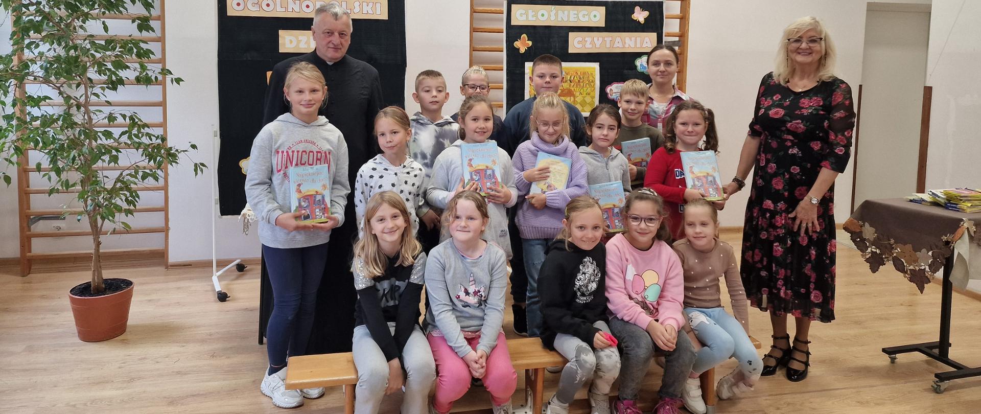 Grupa uczniów z bibliotekarzem, księdzem i wychowawcą klasy II.