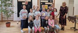 Grupa uczniów z bibliotekarzem, księdzem i wychowawcą klasy II.