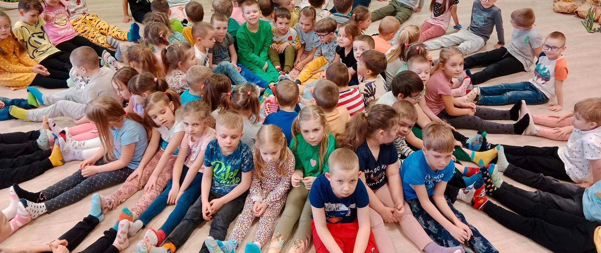 dzieci siedzą tworząc kolo