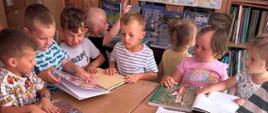 Dzieci oglądają książki podczas wizyty w bibliotece szkolnej