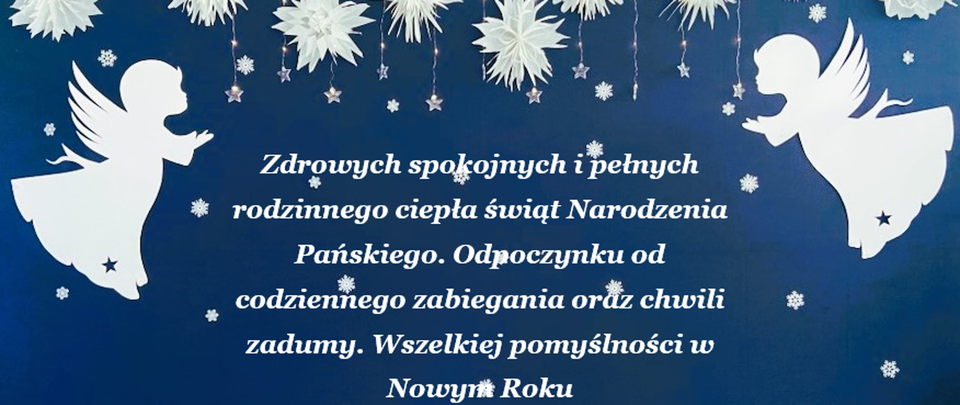 Na niebieskim tle, ze świąreczną girlandą u góry i kształtem aniołów, znajdują się życzenia świąteczne, zawarte w artykule