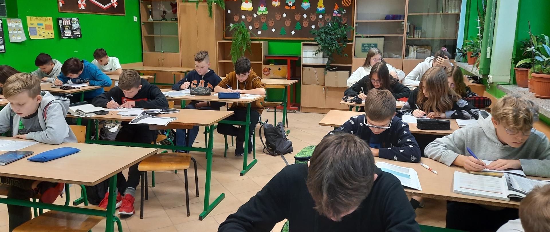 Dzieci siedzące w ławkach szkolnych
