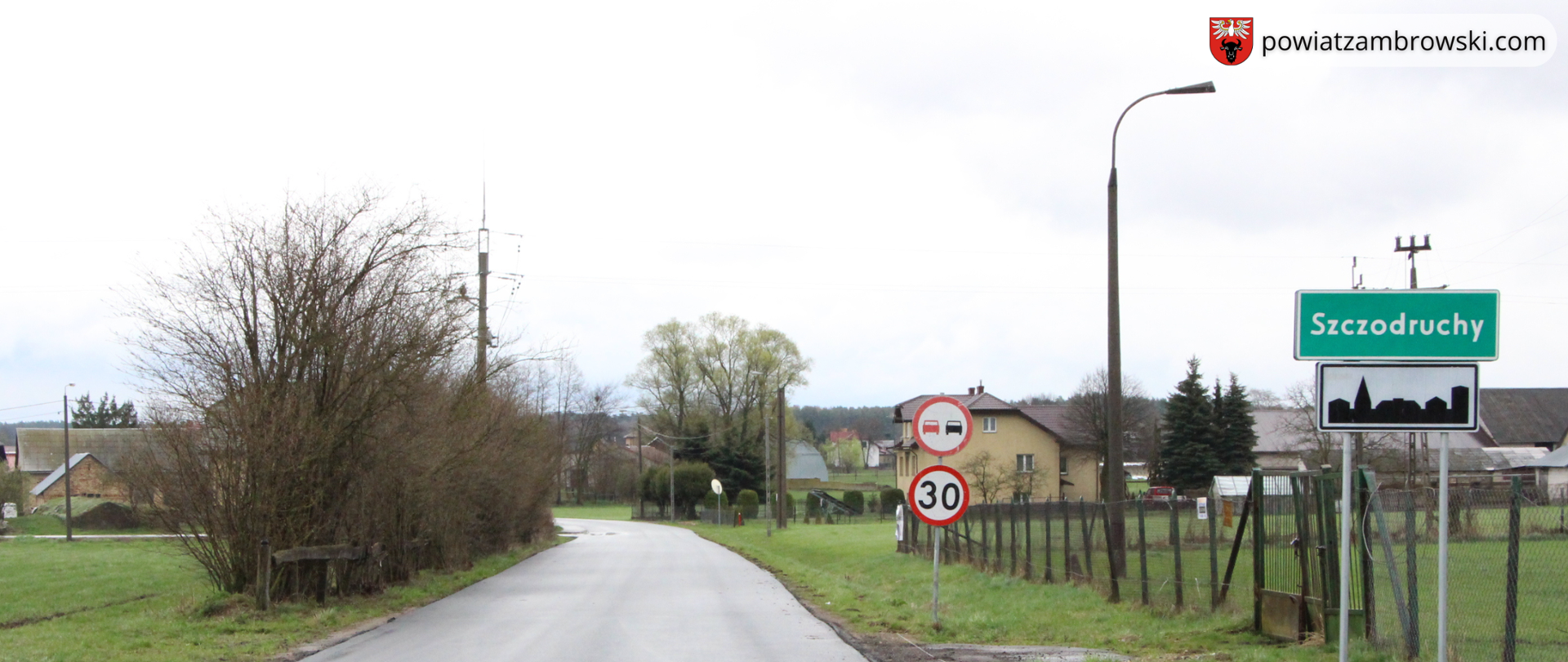 zdjęcie przebudowanej drogi powiatowej od m. Kołaki Kościelne do m. Szczodruchy, po prawej stronie widoczny jest znak z napisem miejscowości "Szczodruchy"