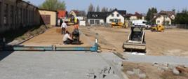 Plac budowy - widok pracowników przy pracy oraz maszyny budowlane