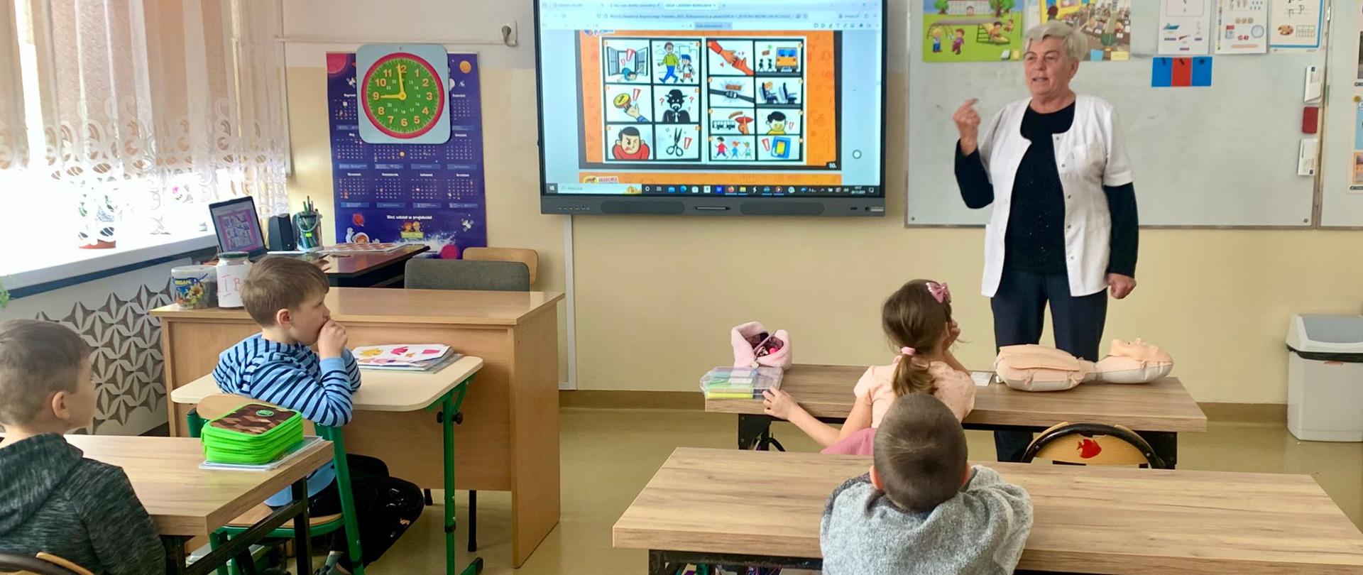Pani higienistka rozmawia z dziećmi o zagrożeniach w szkole.