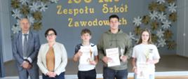 Uczestnicy turnieju z pucharami i dyplomami pozują do zdjęcia wraz z przedstawicielami organizatora