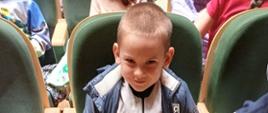 Dzieci siedzą w fotelu, pozują do zdjęcia
