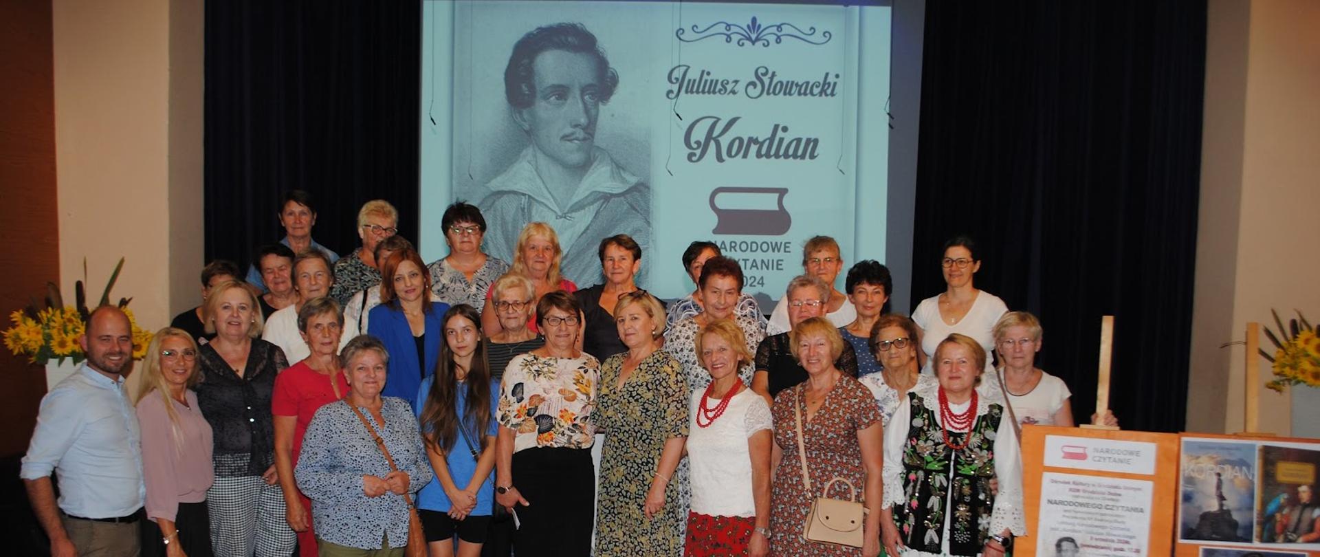 kobiety i jeden mężczyzna w kolorowych ubraniach pozują do wspólnego zdjęcia 