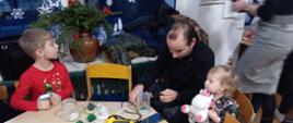 W trakcie warsztatów - przedszkolaki z bliskimi siedzą przy stołach