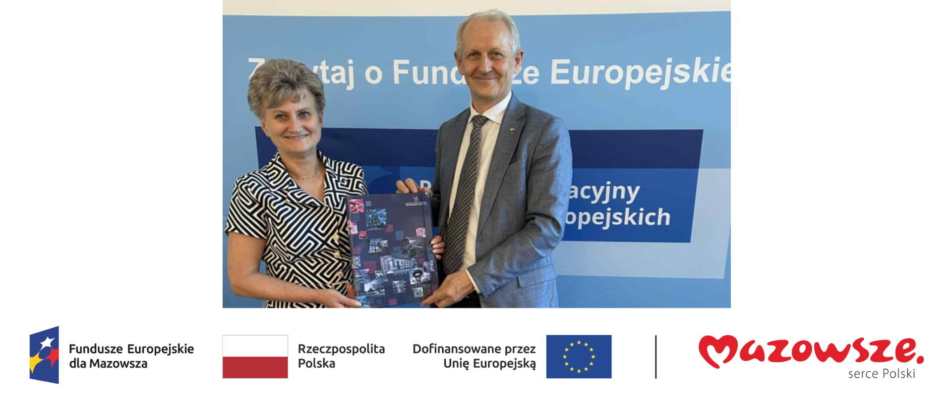 Na zdjęciu dwie osoby dorosłe – kobieta i mężczyzna – stoją przed niebieskim banerem informacyjnym dotyczącym Funduszy Europejskich. Wspólnie trzymają folder promocyjny z grafikami budynków i projektów. U dołu widoczne logotypy: Fundusze Europejskie dla Mazowsza, Rzeczpospolita Polska, flaga Unii Europejskiej oraz „Mazowsze – serce Polski”.