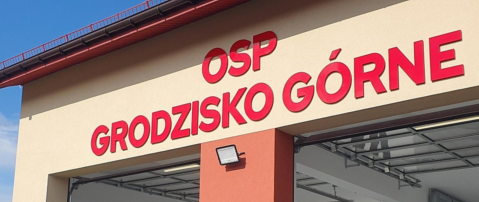 ksiądz w białej komży poświęca budynek remizy 