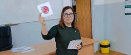 Prowadząca zajęcia prowadzi quiz - pokazuje karty przestawiające różne odpady