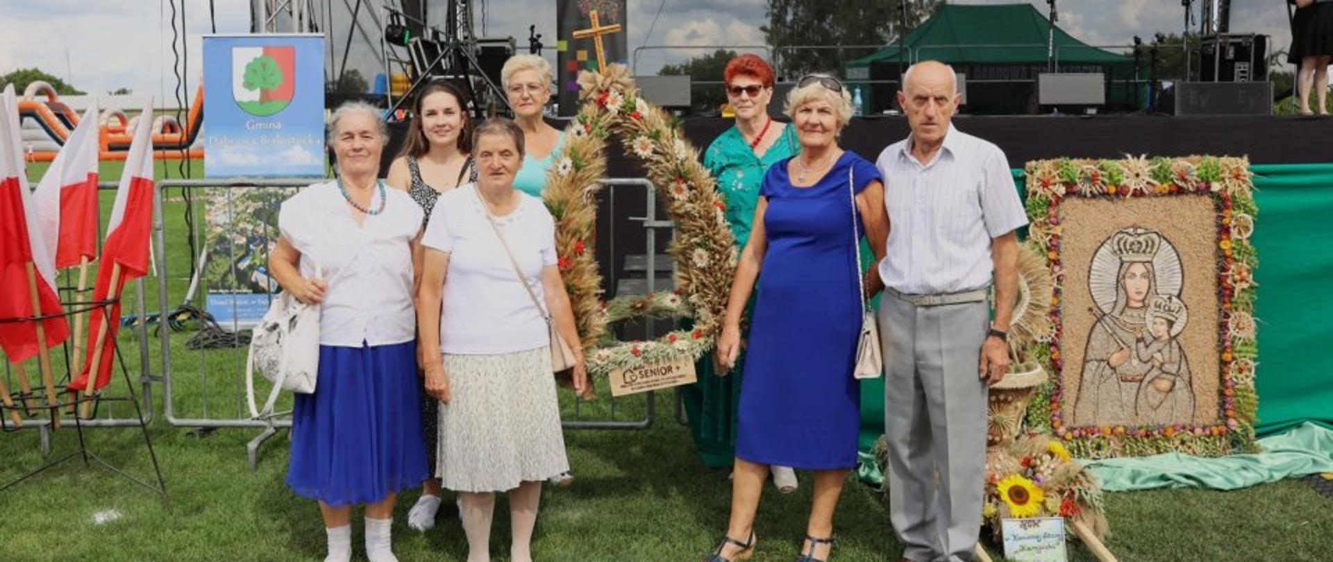 Członkowie Klubu Senior+ pozujący z wieńcem dożynkowym