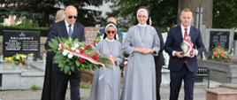 Starosta Zambrowski, siostry Boromeuszki oraz Wicestarosta Zambrowski składają na grobie poległych żołnierzy wiązankę kwiatów i znicz