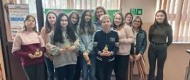 Zdjęcie grupy uczniów z nauczycielem, uczniowie w rękach trzymają upominki.