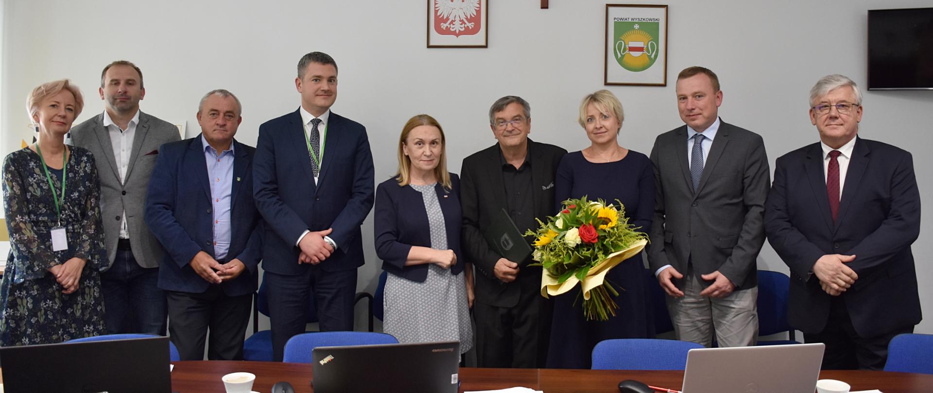 Lidzie stojący obok siebie. Jedna z kobiet trzyma kwiaty,