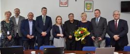 Lidzie stojący obok siebie. Jedna z kobiet trzyma kwiaty,