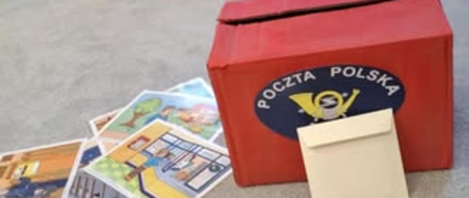 Na dywanie stoi z pudełka zrobiona skrzynka na listy a przed nią rozsypane listy.